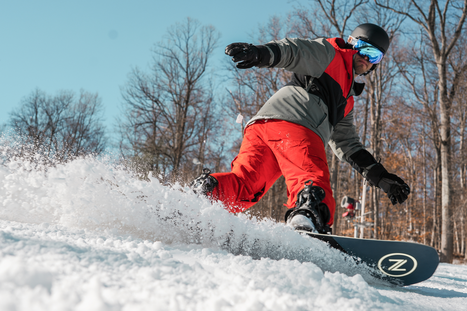 A snowboarder enjoys fresh snow and bluebird skies at Liberty Mountain Resort